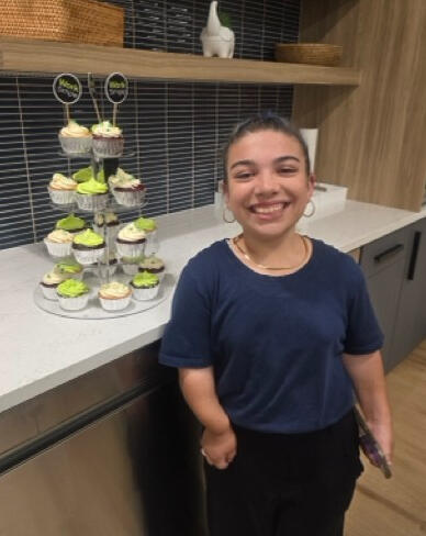 Rylee, owner of Rylee's Sunrise Bakery Rylee of Rylee's Sunrise Bakery with a tower of homemade cupcakes